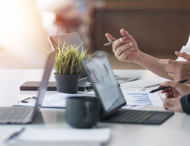 Two business people advisor talking, planning analyze investment and marketing on tablet in office. Working with graph chart of business information.